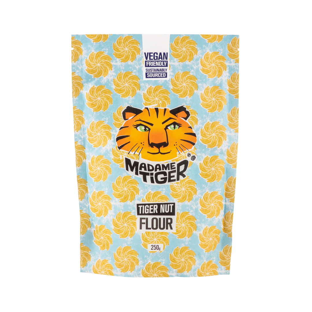 Packaging of Madame Tiger Tiger Nut Flour with tiger face logo on a blue background with yellow swirls.