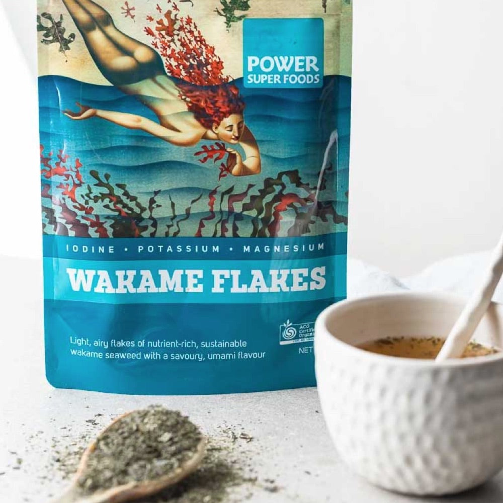 Bag of Power Super Foods Wakame Flakes with a bowl and spoon on a light background