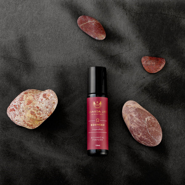Nouveau botanical perfume oil roller with rose stones styled fragrance scene