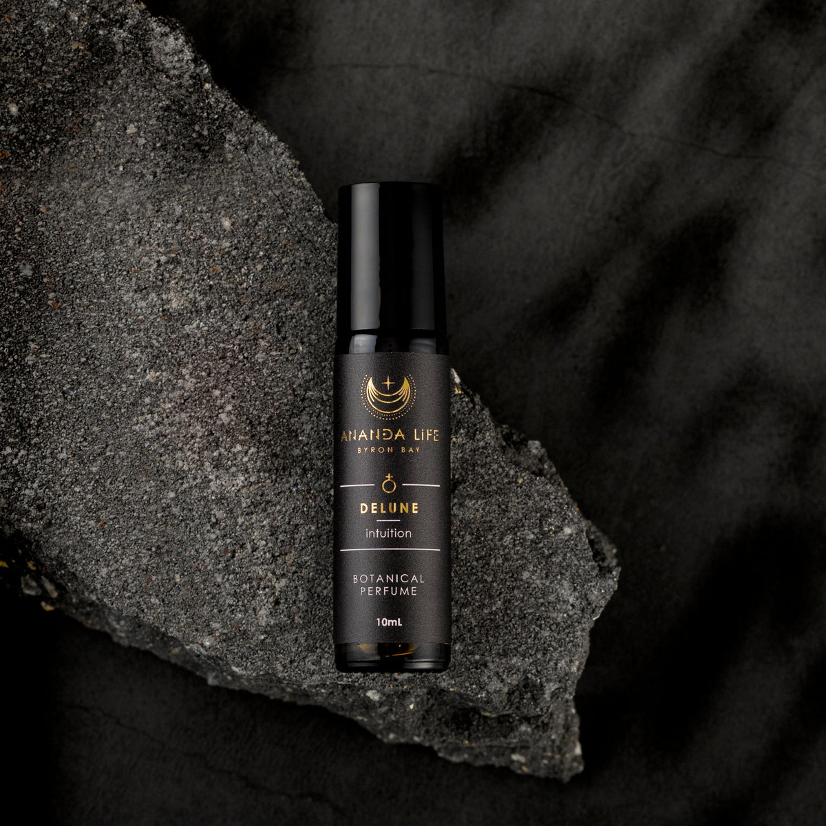 Delune botanical perfume oil roller bottle on dark stone natural fragrance – Ananda Life