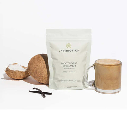 Cymbiotika Nootropic Creamer package with a glass of creamer and coconut ingredients on a white background