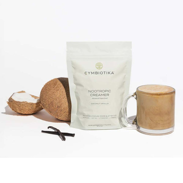 Cymbiotika Nootropic Creamer package with a glass of creamer and coconut ingredients on a white background