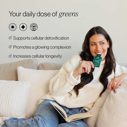 Woman holding a green supplement package on a couch with text about its benefits.