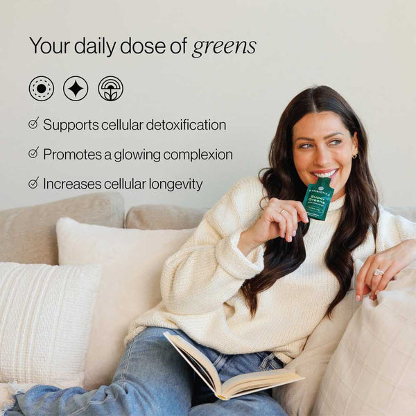 Woman holding a green supplement package on a couch with text about its benefits.