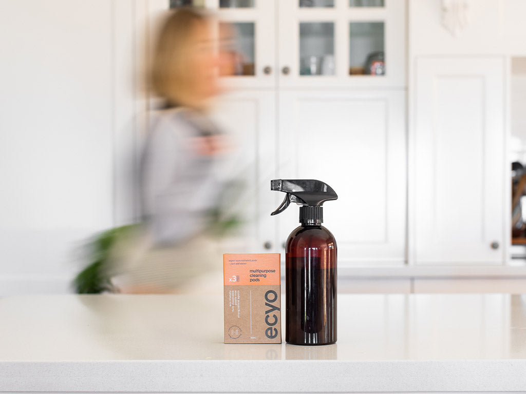 Ecyo brown spray bottle and box on a kitchen counter with blurred background