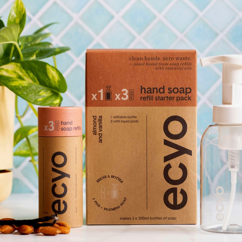 Ecyo eco-friendly hand soap refill kit with cardboard box and bottles on a light blue tiled background.