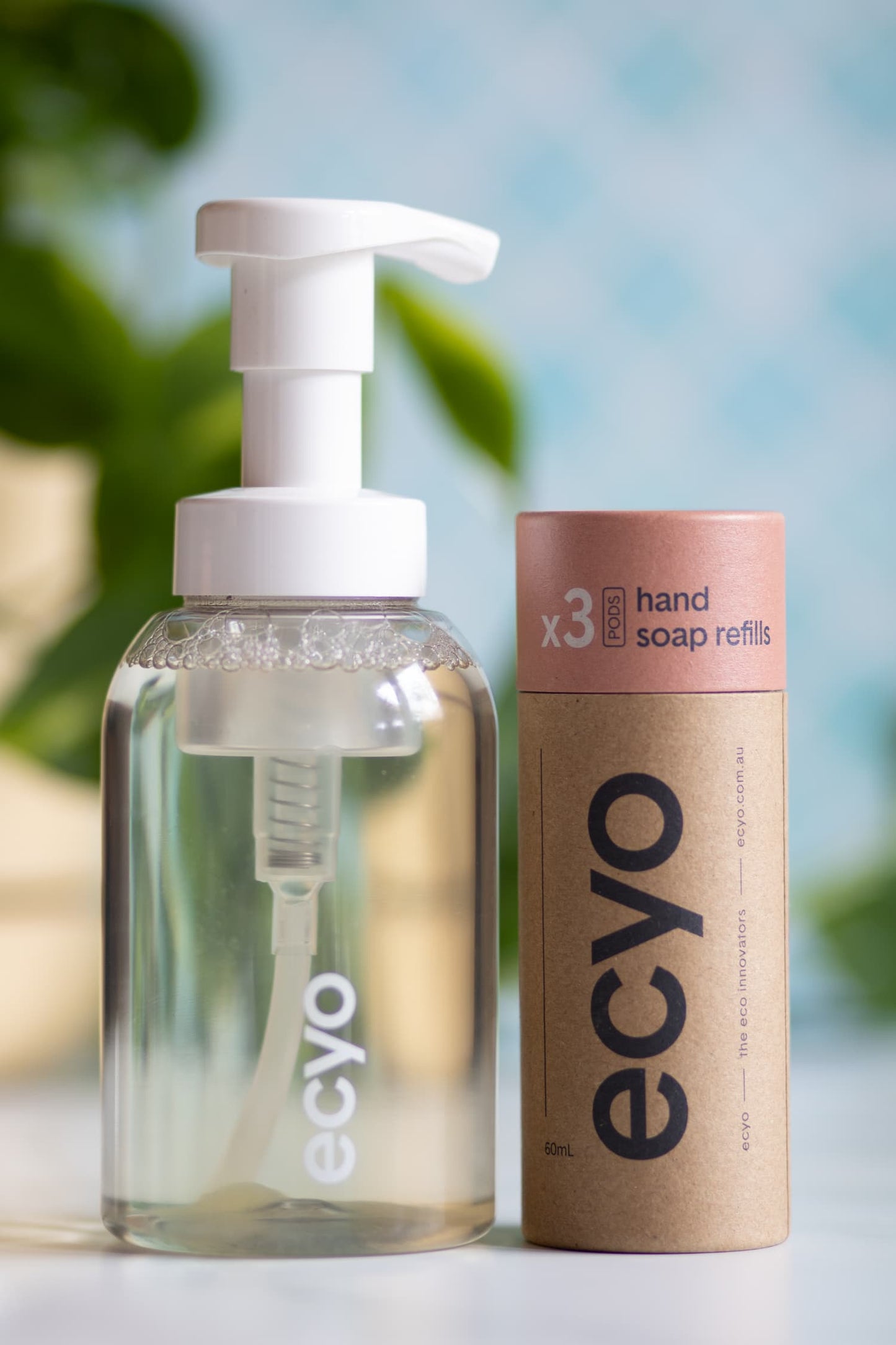 Eco-friendly hand soap bottle and refills with 'ecyo' branding on a blurred natural background