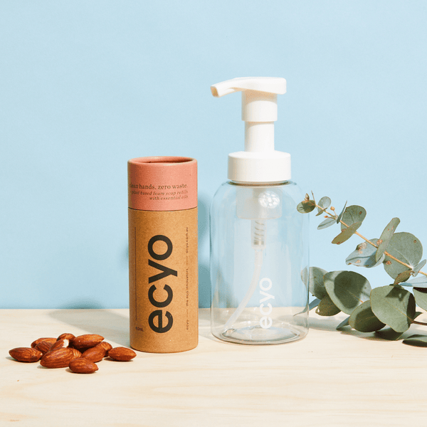 Ecyo eco-friendly bottle and hand soap packaging with almonds and eucalyptus on a light blue background