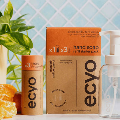 Ecyo eco-friendly mandarin and bergamot hand soap refill pack with bottle and packaging on a light blue tiled background.