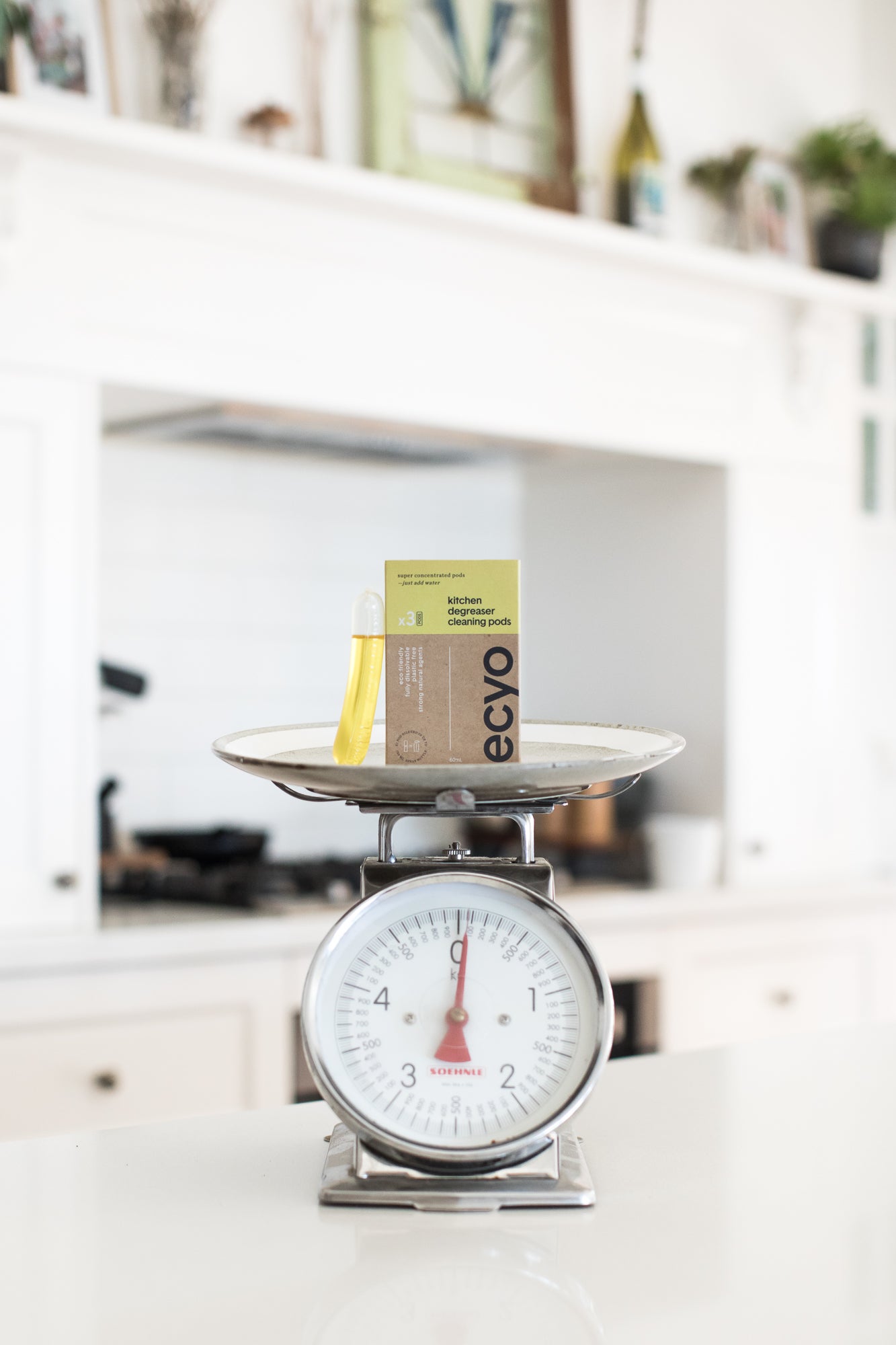Eco-friendly cleaning product on a kitchen scale with a blurred kitchen background