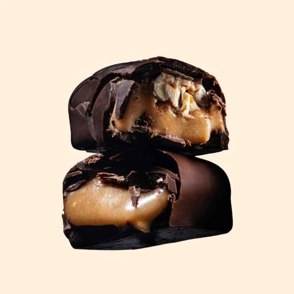 Chocolate-covered candy with a caramel filling on a beige background