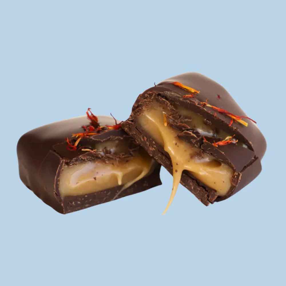Chocolate-covered candy with a gooey center on a light blue background