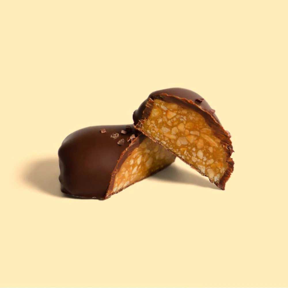 Chocolate-covered caramel bar on a beige background