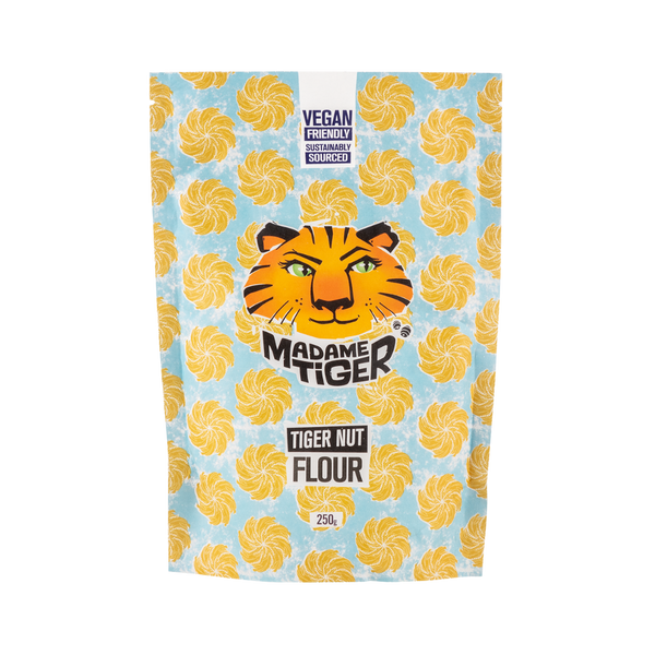 Packaging of Madame Tiger Tiger Nut Flour with tiger face logo on a blue background with yellow swirls.