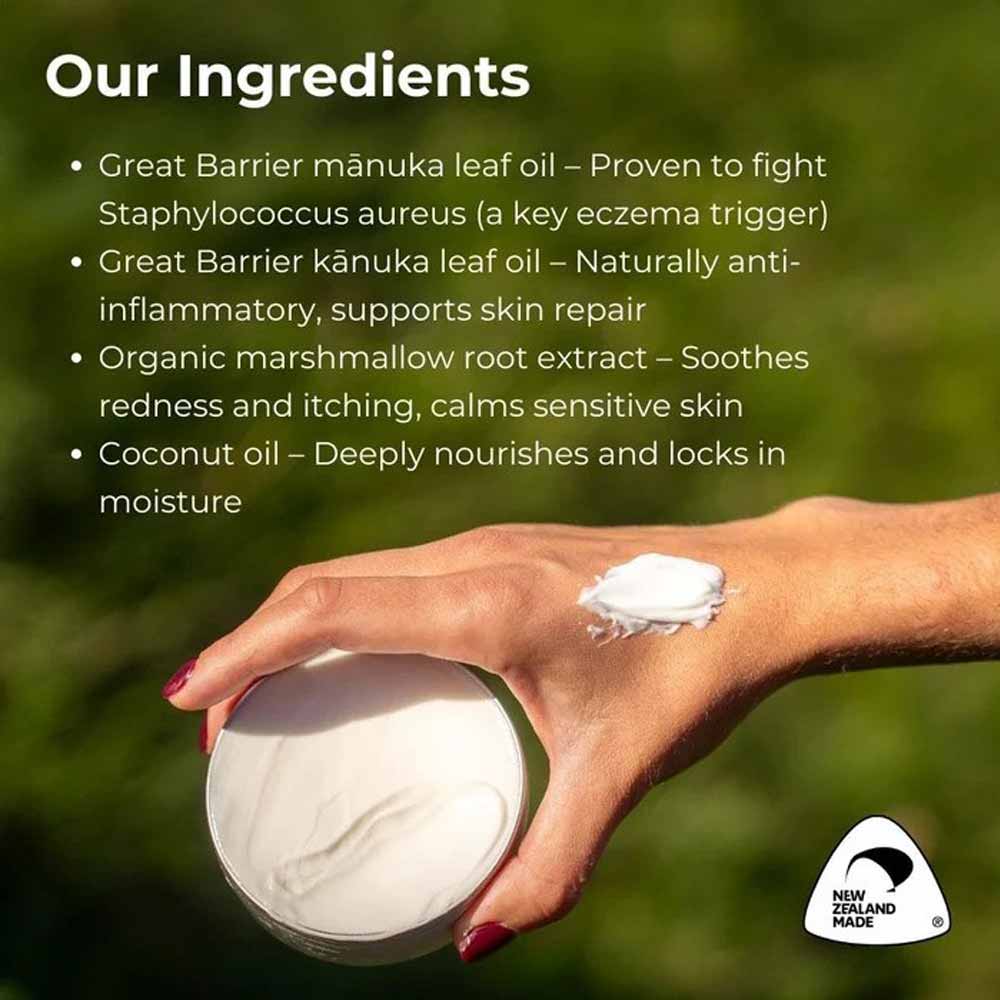 Hand holding a container of cream with text about ingredients on a green background